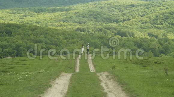 年轻夫妇手牵手在田野里视频的预览图