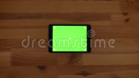 水平平板的顶部镜头绿色屏幕上的木制桌子背景视频的预览图