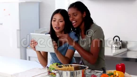 在平板电脑上使用在线食谱的年轻女性视频的预览图