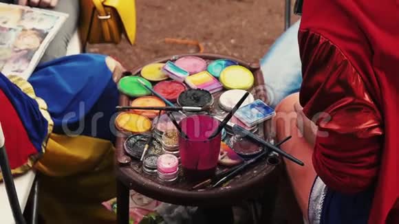 许多彩色染料和刷子的视图穿西装的女孩夏季节日视频的预览图