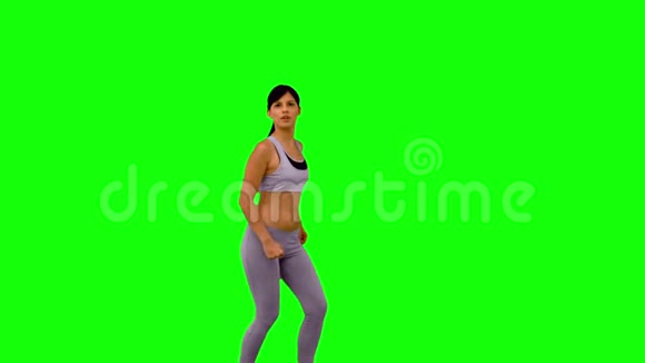 运动女性在绿色屏幕上跳跃和摆姿势视频的预览图