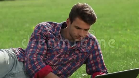 年轻的帅哥躺在草地上视频的预览图