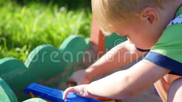 孩子玩沙箱里的玩具夏日阳光明媚户外娱乐和游戏视频的预览图