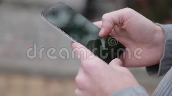 一个手里拿着手机智能手机的男人视频的预览图