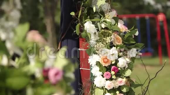 户外婚礼的婚礼装饰用白色和粉红色玫瑰装饰的木制拱门蜜蜂和大黄蜂视频的预览图