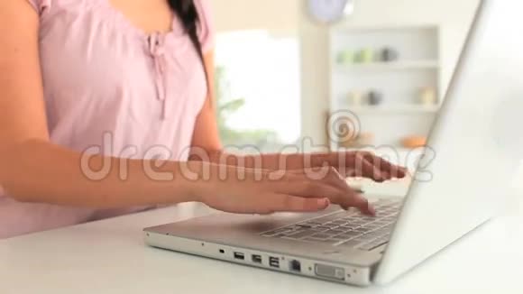 女人在使用笔记本电脑时接电话视频的预览图