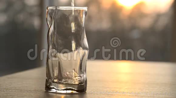 日落时分清水倒入玻璃杯中视频的预览图