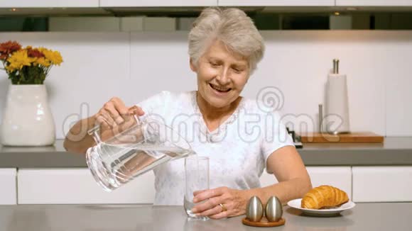 快乐的女人为早餐倒了一杯水视频的预览图