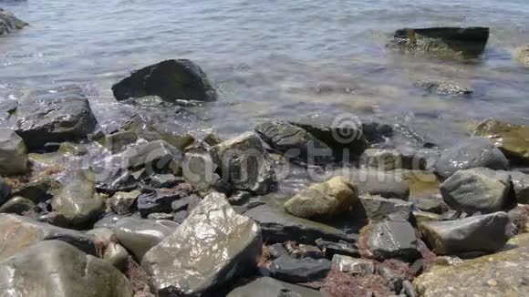 正面看海浪在岩石上破碎岩石与大海中的大石头和波浪与泡沫视频的预览图
