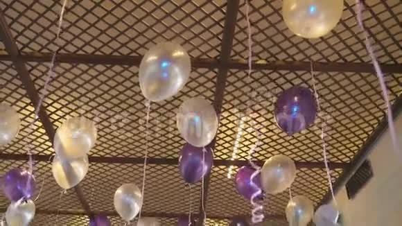 漂浮在天花板上的白色和紫色气球视频的预览图