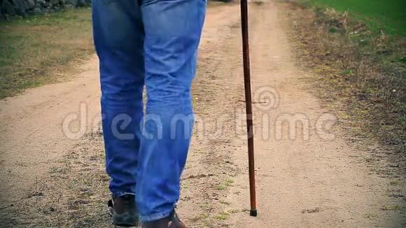 一个拿着拐杖的人走在路上视频的预览图