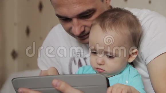 爸爸和儿子在平板电脑上玩视频的预览图