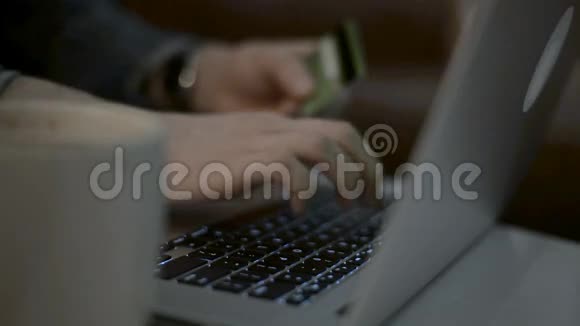 网上购物概念女人手拿着信用卡用笔记本电脑视频的预览图