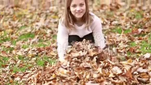 可爱的女孩扔树叶视频的预览图