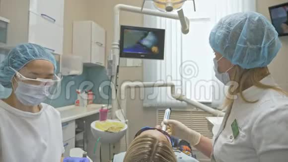 医生用特殊的口腔内检查数字微型相机检查牙齿监控牙医和病人看录像视频的预览图