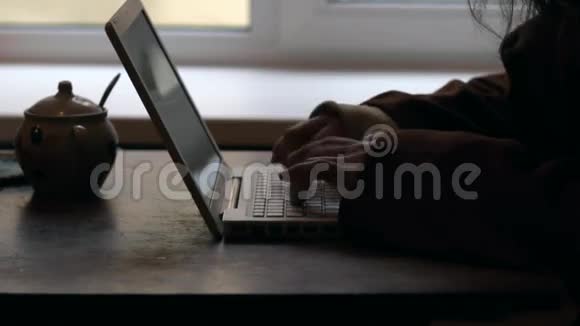 戴帽子的人在笔记本电脑上打字视频的预览图