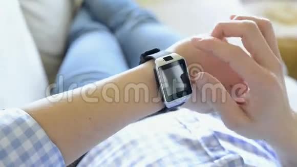 使用智能手表躺在沙发上的男人视频的预览图