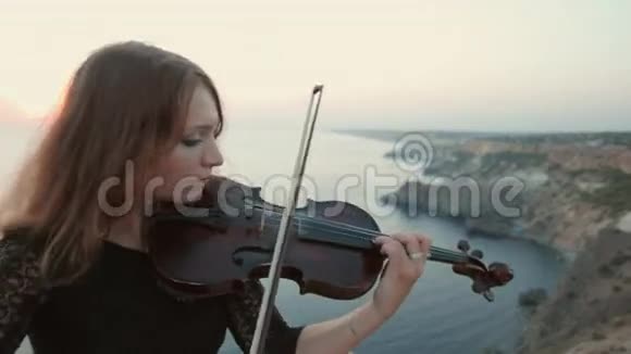 小提琴手站在海边的悬崖上演奏视频的预览图