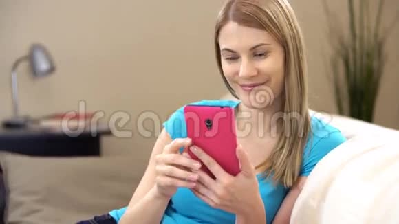 漂亮迷人的年轻女人有一部智能手机通过信使与朋友交流视频的预览图