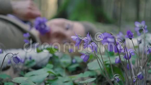 美丽的少女躺在森林的花朵里视频的预览图
