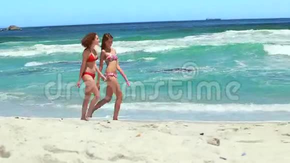 两个朋友一起沿着海滩散步视频的预览图