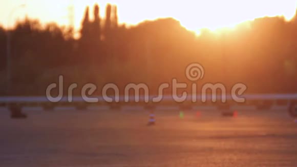 摩托车驾驶课MotoGymkhana摩托车手在夕阳下的背景循环视频的预览图