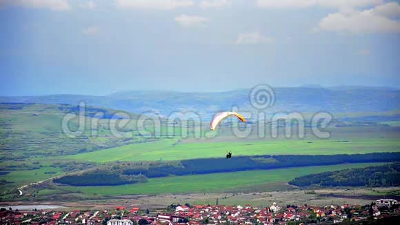 城市村庄上方的降落伞视频的预览图