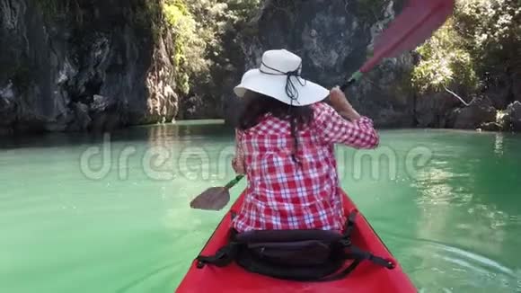 女子皮划艇在美丽的泻湖动作镜头下的后视角女孩皮划艇视频的预览图