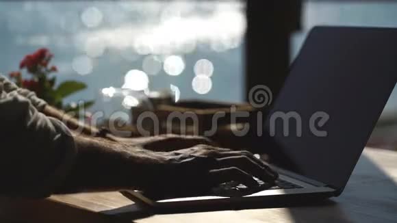 年轻的商人用他的笔记本电脑在海边背景视频的预览图
