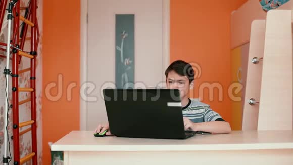 那少年正坐在桌旁用笔记本电脑视频的预览图