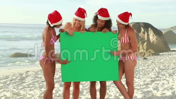 四个女孩在海滩上戴圣诞帽视频的预览图