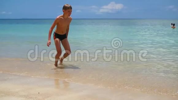快乐的孩子在热带海洋的海岸上嬉戏视频的预览图