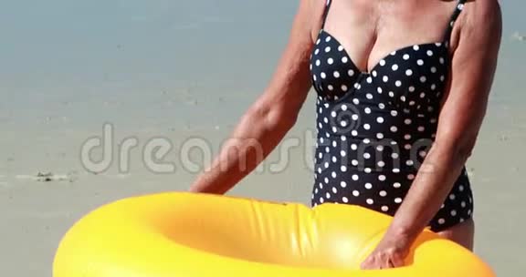 一位在海滩游泳圈的老妇人视频的预览图