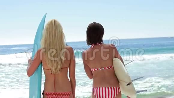 两名女性冲浪者在海滩上冲浪视频的预览图