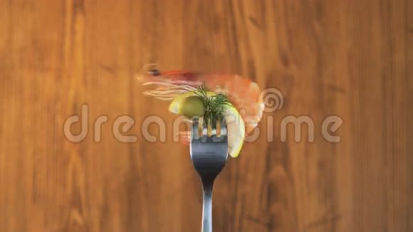 木制背景上用对虾和柠檬旋转叉子视频的预览图