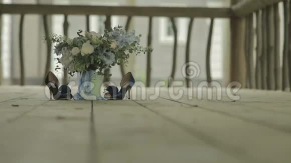 木制地板上的新娘花束和蓝色鞋子视频的预览图