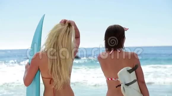 两个冲浪的女人在海边视频的预览图