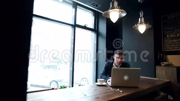 年轻人在街上一边喝咖啡一边用平板电脑视频的预览图