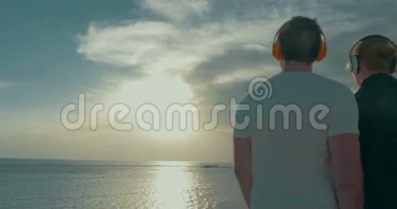 戴着耳机欣赏海天一色的年轻夫妇视频的预览图