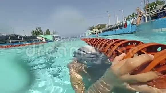 在游泳池里游泳的男孩的水下镜头视频的预览图
