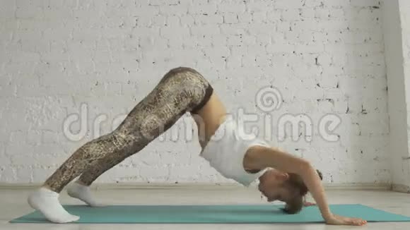 年轻美丽的瑜伽在白色砖墙背景下健康的生活方式视频的预览图