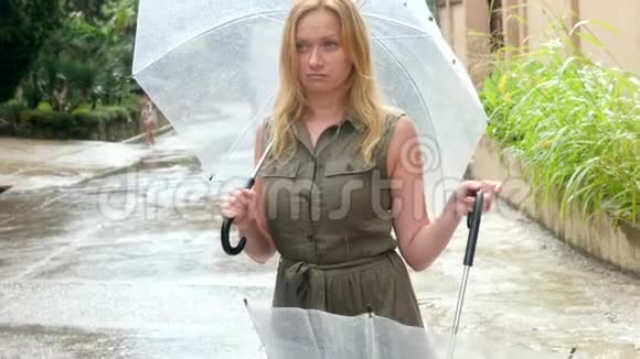 一个女人站在伞下夏天倾盆大雨4k慢镜头视频的预览图