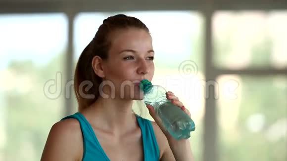 年轻的金发女人在喝水视频的预览图
