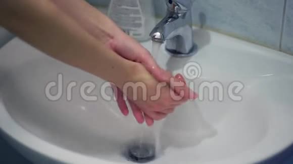 女孩在白色水槽里用液体肥皂洗手视频的预览图