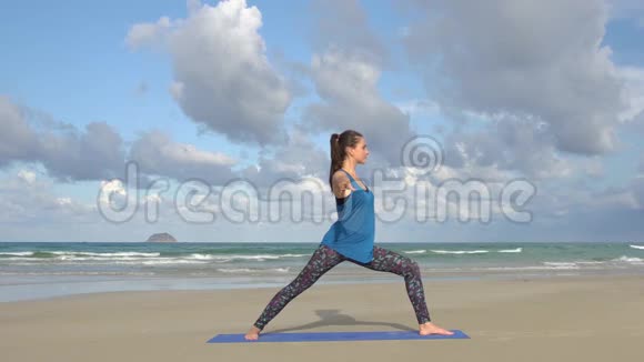 日出时年轻女子在海滩上练习瑜伽视频的预览图