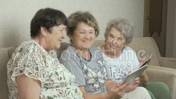 老年妇女在平板电脑屏幕上观看照片视频的预览图