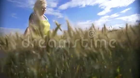 女人走在金黄的大麦地微笑着慢悠悠地走着视频的预览图