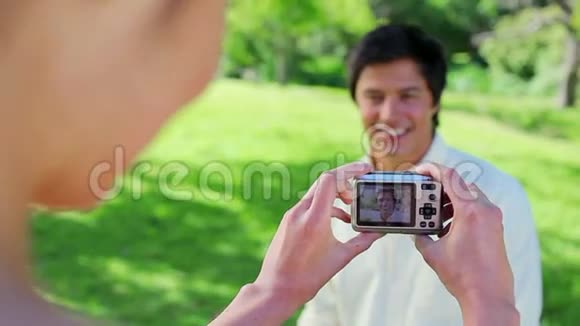 快乐的女人拍她男朋友的照片视频的预览图