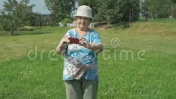 一位老年妇女在公园内拍照视频的预览图