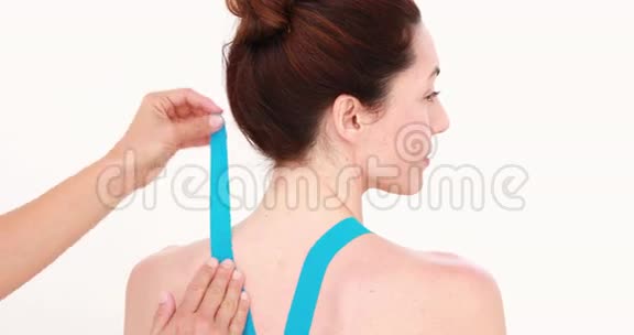 物理治疗师在病人的背部贴上阻力带视频的预览图
